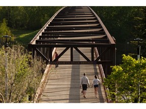 Walkers enjoy a warm spring evening crossing the Ainsworth Dyer Bridge at Rundle Park in Edmonton, on Friday, May 29, 2020. Photo by Ian Kucerak/Postmedia