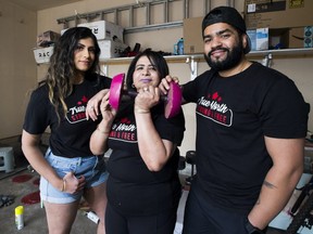 Barjinder Cheema (centre), her daughter-in-law Amanveer (left) and son Damanjeet work to build weights using concrete in their garage on Wednesday, May 6, 2020, in Edmonton. They started doing this once gyms closed and have been working five to six hours a day to keep up with a ton of orders they've been getting for home gym weights.