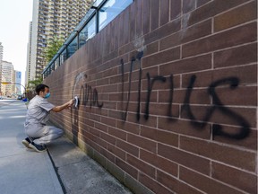 Racist graffiti on the Chinese consulate's wall in Calgary is being cleaned on Wednesday, May 27, 2020.