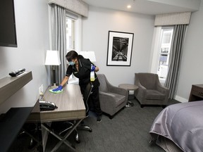 Cheryl Welz wipes down a hotel room with disinfectant at Union Bank Inn, 10053 Jasper Ave., in Edmonton Tuesday June 23, 2020.