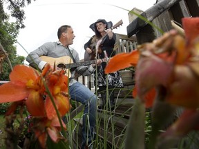 Nick Guiton and Jenn Durrant perform a song on the front steps of a home in Edmonton Sunday June 28. The duo will be participating in a porch concert series being hosted by Arts on the Avenue.