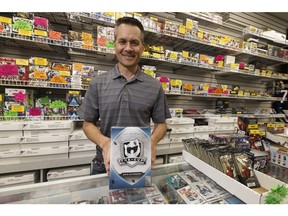 Wayne Wagner, owner of Wayne's Sports Cards in west Edmonton, holds a pack of Upper Deck The Cup cards. An online auction for a Connor McDavid The Cup rookie card numbered 97 of 99 has a current bid of more than $70,000 US.