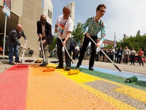 MacEwan University's LGBTQ2S+ community, faculty, staff and visitors paint a rainbow sidewalk as the institution unveils a series of rainbow and transgender-themed crosswalks for Pride Month at the City Centre Campus in Edmonton, on Monday, May 27, 2019. File photo.