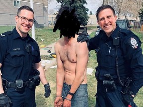 Edmonton Police Service Const. Mike Roblin, left, posted a photo to Instagram of himself and another officer smiling with a shirtless man in handcuffs in between them, his face scribbled out. Roblin's Instagram account appeared to have been deleted on Monday, June 1, 2020.