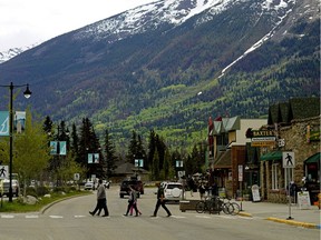 Pedestrians cross the main street in downtown Jasper, Alberta on June 4, 2020. National parks in Alberta re-opened June 1, 2020 after a temporary closure due to the COVID-19 pandemic.