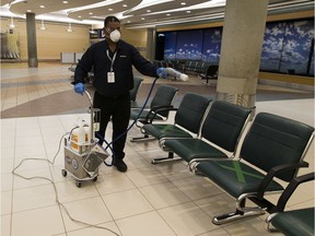 Chowhan Sukhbal Jinder sprays a disinfectant on seats at  the Edmonton International Airport to help stop the spread of the COVID-19 virus on June 17, 2020.