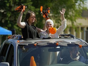 Mom Sharon Harker, left, grandmother Janae Harker, right,  and dad Matt Harker at the wheel celebrate Brant Harker's high school graduation outside McNally High School in Edmonton on Tuesday June 23, 2020. The school held a virtual drive-by outdoor graduation event to celebrate all the high school graduates during the COVID-19 pandemic.