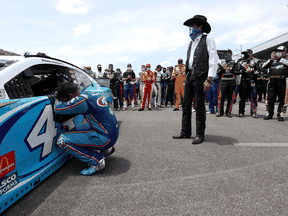 Bubba Wallace, driver of the #43 Victory Junction Chevrolet, kneels as team owner, and NASCAR Hall of Famer Richard Petty and NASCAR drivers stand in solidarity with Wallace prior to the NASCAR Cup Series GEICO 500 on June 22, 2020 in Talladega, Alabama.