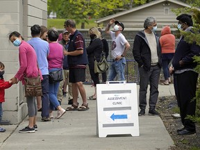 People lined up outside a COVID-19 drop-in testing centre in Edmonton on Wednesday, June 3, 2020. The only testing site in the Edmonton zone is located at Cardinal Collins High School Academic Centre, 7319 29 Ave.