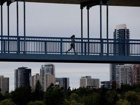 A jogger makes their way across the North Saskatchewan River, on the pedestrian portion of the Dudley B Menzies Bridge, in Edmonton Friday June 26, 2020.