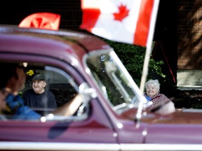 Seniors look on as members of the Edmonton Antique Auto Club hold a Father's Day parade near the St. Michael's Long Term Care Centre in Edmonton, June 19, 2020.