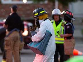 An Edmonton Fire Rescue Service fire investigator returns a cat to some residents after a fire damaged an apartment building at 13125 69 Street in Edmonton, on Wednesday, June 10, 2020.