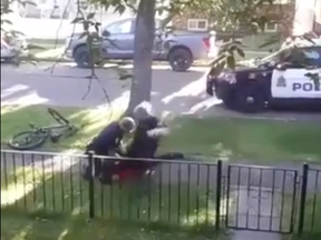An Edmonton police officer is seen jumping with his knee onto a man lying on the ground during a 2019 arrest.