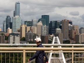 A walker in a COVID-19 mask looks over the city while walking along Saskatchewan Drive. A heat warning was issued for the Edmonton area on July 27, 2020.
