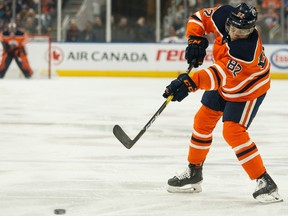 Edmonton Oilers' Caleb Jones (82) fires a puck at Winnipeg Jets' goaltender Connor Hellebuyck (37) at Rogers Place in this file photo from Feb. 29, 2020.