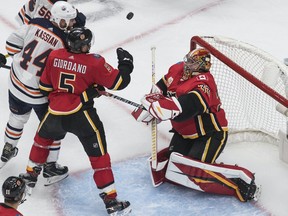 The Calgary Flames’ Mark Giordano and Edmonton Oilers’ Zack Kassian battle for the rebound as Flames goalie David Rittich makes the save during an NHL exhibition game at Rogers Place in Edmonton on Tuesday, July 28, 2020.
