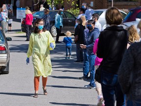 People line up to be tested for COVID-19 at the Richmond Road Diagnostic and Treatment Centre in Calgary on Wednesday, June 3, 2020.