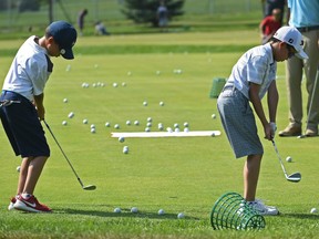 Golf balls litter the green as practice makes prefect for these junior golfers during a clinic on the practice green at the Victoria Golf Club in Edmonton, July 29, 2018.