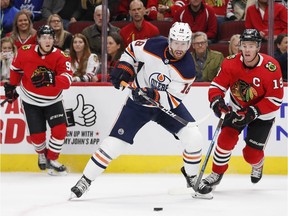 Edmonton Oilers left wing James Neal (18) looks to control the puck against Chicago Blackhawks center Jonathan Toews (19) during the first period at United Center on Monday, Oct. 14, 2019.