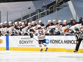 Kailer Yamamoto of the Edmonton Oilers celebrates with teammates on the bench after scoring against the Calgary Flames ahead of the 2020 NHL Stanley Cup Playoffs at Rogers Place on July 28, 2020.