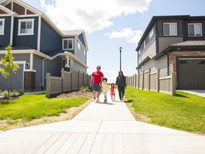 Frederick and Tonibelle Pahanonot walk with their children, Derek, 5, and Isabella, 2, in their new community of Rosewood at Secord.