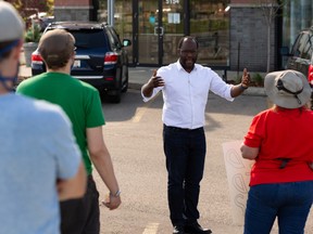 Demonstrators protesting the government’s return to class plan speak with MLA Kaycee Madu (second from right) outside his office during a demonstration in Edmonton, on Friday, Aug. 21, 2020.