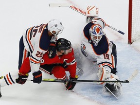 Edmonton Oilers defencemen Darnell Nurse (25) shoves Chicago Blackhawks forward Jonathan Toews (19) into Edmonton Oilers goaltender Mikko Koskinen (19) during the first period in the Western Conference qualifications at Rogers Place on Friday, Aug. 8, 2020.