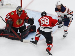 dmonton Oilers forward Kailer Yamamoto (56) battles for a loose puck with Chicago Blackhawks defensemen Slater Koekkoek (68) in front of Chicago goaltender Corey Crawford (50) during the third period in the Western Conference qualifications at Rogers Place on Aug. 7, 2020.