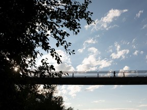 A runner crosses the Terwillegar Park Footbridge over the North Saskatchewan River in Edmonton, on Wednesday, Aug. 12, 2020. The bridge will be closed at night from 9pm to 7am for maintenance from Aug. 13 -21.