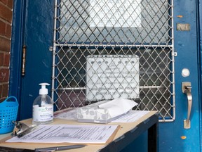 A hand sanitizer station to protect staff against COVID-19 is seen outside the back door of Mount Royal Elementary in Edmonton, on Monday, Aug. 17, 2020. Schools are being prepared for the return of students during the COVID-19 pandemic.