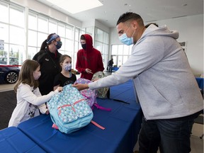 CAN MAN DAN, Dan Johnstone, takes part in the 8th Annual Back-To-School event on Sunday, Aug. 30, 2020 at Wolfe Cadillac, Westgate Chevrolet in Edmonton as he helps Melodee Bieniek,8, and her sister Kailee ,7, along with their mom, Amanda Cooney and brother Braidon Cooney.  The event will assist over 2,000 kids who are registered through the CAN MAN DAN Foundation. Kids pick up their school supplies & personal hygiene items plus receive food hampers for their families.