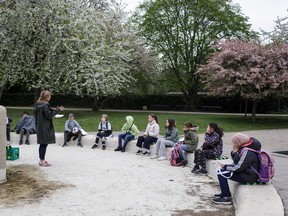 Teacher Marie Kaas-Larsen speaks with her pupils of the Norrebro Park primary school outside in a nearby park in Copenhagen, Denmark on April 29, 2020. - Denmark was the first country in Europe to reopen its schools for the youngest pupils on April 15. In addition to practicing social distancing and regular handwashing, classes must be held outdoors as much as possible to limit the spread of the virus.