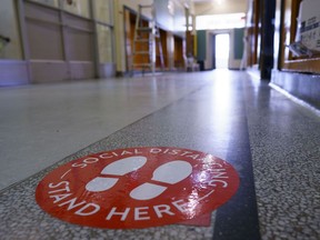 A social distancing sticker is seen on the floor of a hallway in preparation for the new school year at the Willingdon Elementary School in Montreal, on Wednesday, August 26, 2020.
