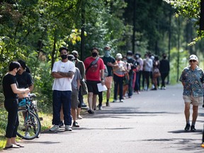People wait in line at a COVID-19 testing facility in Burnaby, B.C., on Thursday, August 13, 2020. A new public opinion study suggests Canadians believe the COVID-19 crisis has brought their country together, while Americans blame the pandemic for worsening their cultural and political divide.