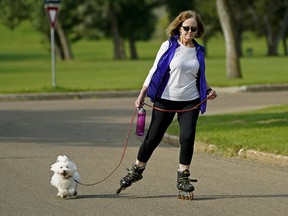 A Coton dog named Zoey takes her human Lorna Pederson out for a skate at Hawrelak Park in Edmonton on Wednesday August 19, 2020. (Photo by Larry Wong/Postmedia)