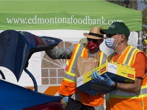 Volunteers unload donations during the Edmonton Food Banks' drive thru Heritage Food Drive in the Southgate Centre mall parking lot, in Edmonton Saturday Aug. 1, 2020. Traditionally the Edmonton Food Bank would be collecting donations at the Heritage Festival.