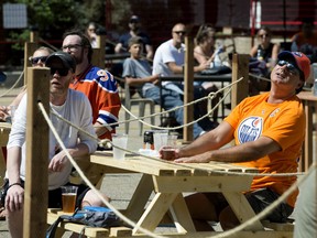 Edmonton Oilers' fans watch the first game of the  Oilers and Chicago Blackhawks best-of-five NHL playoff qualifying series from the patio at Campio Brewing Co., 10257 105 St., in Edmonton on Saturday, Aug. 1, 2020.