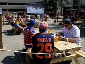 Edmonton Oilers' fans watch the first game of the  Oilers and Chicago Blackhawks best-of-five NHL playoff qualifying series from the patio at Campio Brewing Co., 10257 105 St., on Saturday, Aug. 1, 2020.