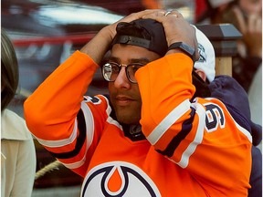 An Edmonton Oiler fan reacts to the team's loss to the Chicago Blackhawks and elimination from the NHL playoffs in downtown Edmonton on Friday, Aug. 7, 2020.