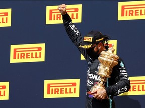 Mercedes' Lewis Hamilton celebrates winning the race on the podium with the trophy