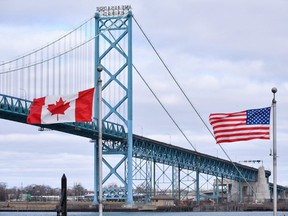 Canadian and American flags fly near the Ambassador Bridge at the Canada-USA border crossing in Windsor, Ont. on Saturday, March 21, 2020.