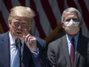 Dr. Anthony Fauci (R), director of the National Institute of Allergy and Infectious Diseases, looks on as U.S. President Donald Trump delivers remarks about coronavirus vaccine development in the Rose Garden of the White House on May 15, 2020 in Washington, DC.