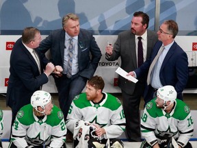 Head coach Rick Bowness of the Dallas Stars, second from left, and his assistants, Derek Laxdal, left, Todd Nelson, second from right, and John Stevens, right, talk on the bench during the game against the Colorado Avalanche in Game 1 of the Western Conference Second Round during the 2020 NHL Stanley Cup Playoffs at Rogers Place on August 22, 2020.