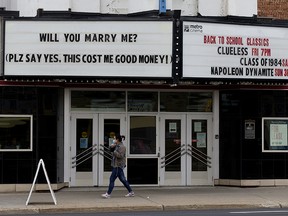 Pedestrians walk under the Metro Cinema (Garneau Theatre) marquee, in Edmonton Monday Aug. 31, 2020. A theatre representative says the marriage proposal was accepted. The theatre marquee has hosted 2 marriage proposals this year. The theatre began renting out it's marquee earlier in the year when COVID-19 restrictions closed the facility. The theatre has since reopened. Photo by David Bloom