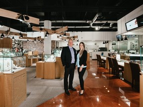 A man and a young woman pose in a large jewellrey store