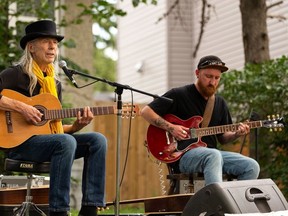 Bill Bourne (left) and guitarist Paul Steffes perform at a front porch block party concert at a home in the Allendale neighbourhood.