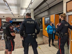 Police are seen at a Calgary airport gate before a red-eye flight to Toronto early on Sept. 8, 2020. A family of four was removed from the flight after their two young children were not wearing masks, the family says. The flight was ultimately cancelled.