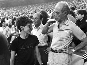 Former prime minister Pierre Trudeau shows how tall his eldest son Justin has grown in relation to himself during the seventh inning stretch at the Montreal Expos game in Montreal on April 20, 1987.