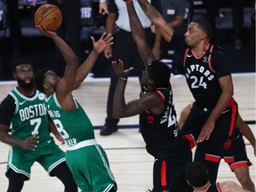 Boston Celtics guard Kemba Walker (8) shoots against Toronto Raptors guard Norman Powell (24) and forward Pascal Siakam (43) in the second half in game six of the second round of the 2020 NBA Playoffs at ESPN Wide World of Sports Complex.