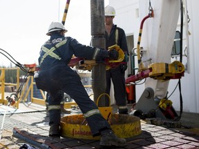 Employees torque a pipe at a wedge well at Christina Lake, a situ oil production facility half owned by Cenovus Energy Inc. and ConocoPhillips, in Conklin, Alberta, Canada, on Thursday, Aug. 15, 2013. Cenovus Energy Inc. is Canada's fourth-largest oil producer.